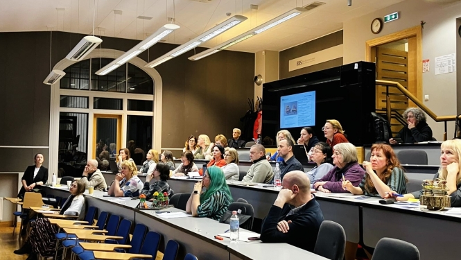 Cilvēki sēž auditorijā