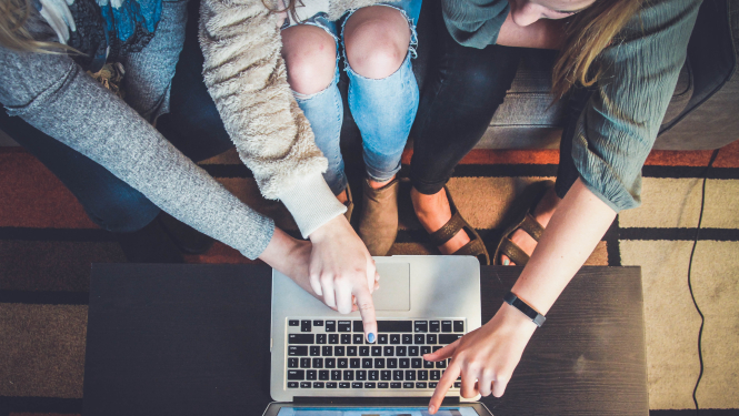 Cilvēki norāda uz datora ekrānu.