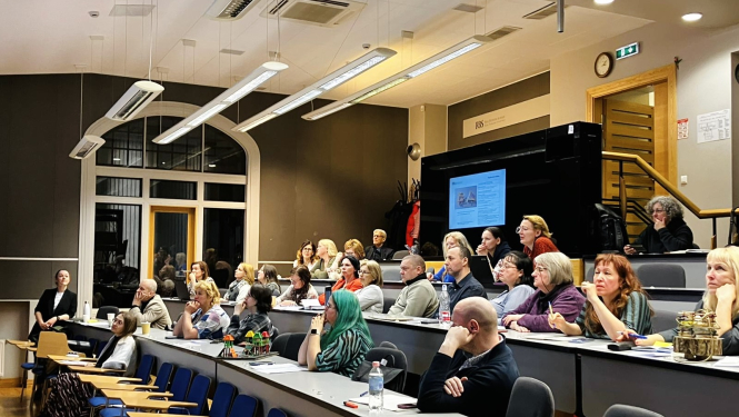 Cilvēki sēž auditorijā