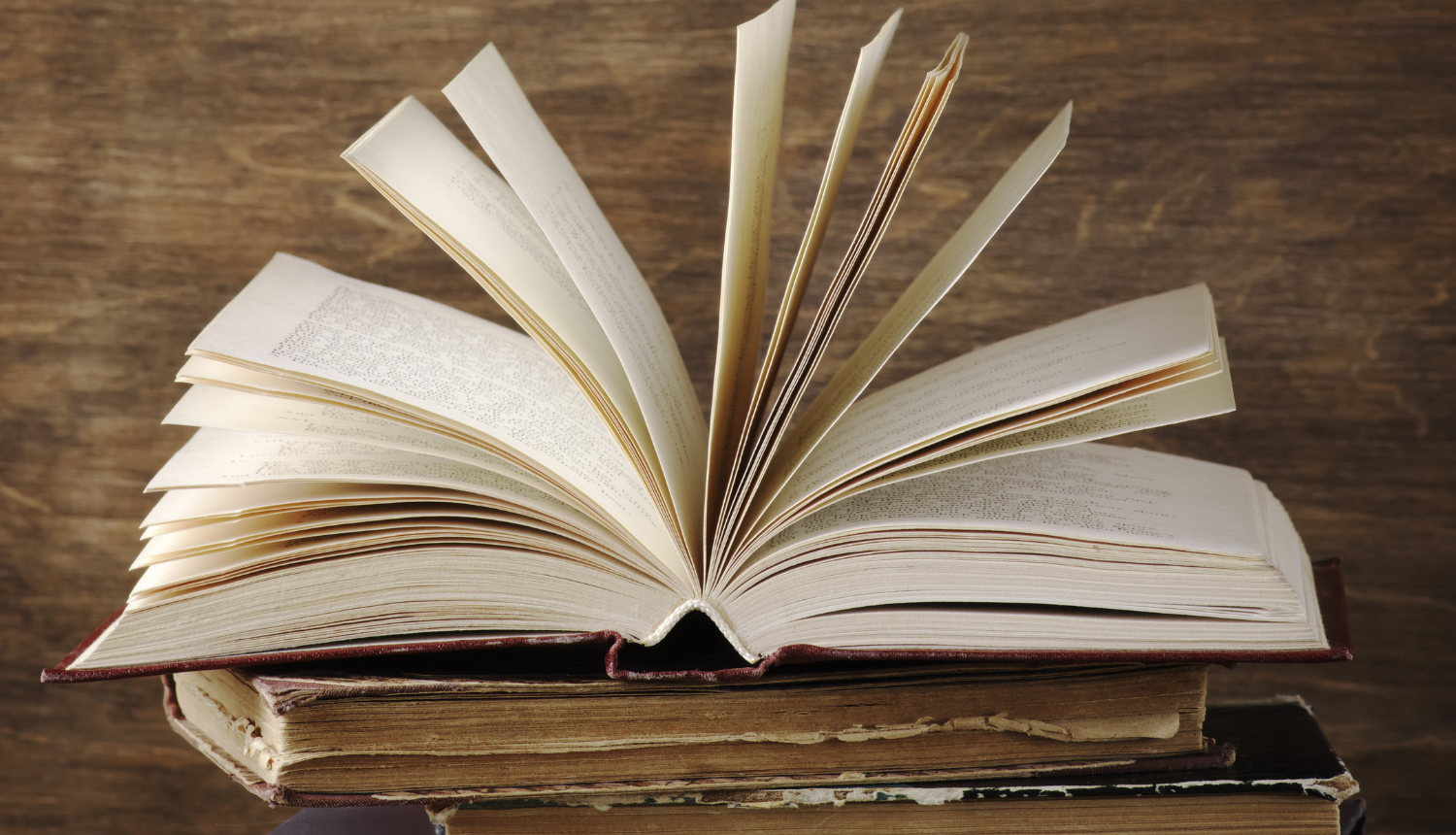 Ilustratīvs attēls - vairākas vecas grāmatas, augšējā ir atvērta.