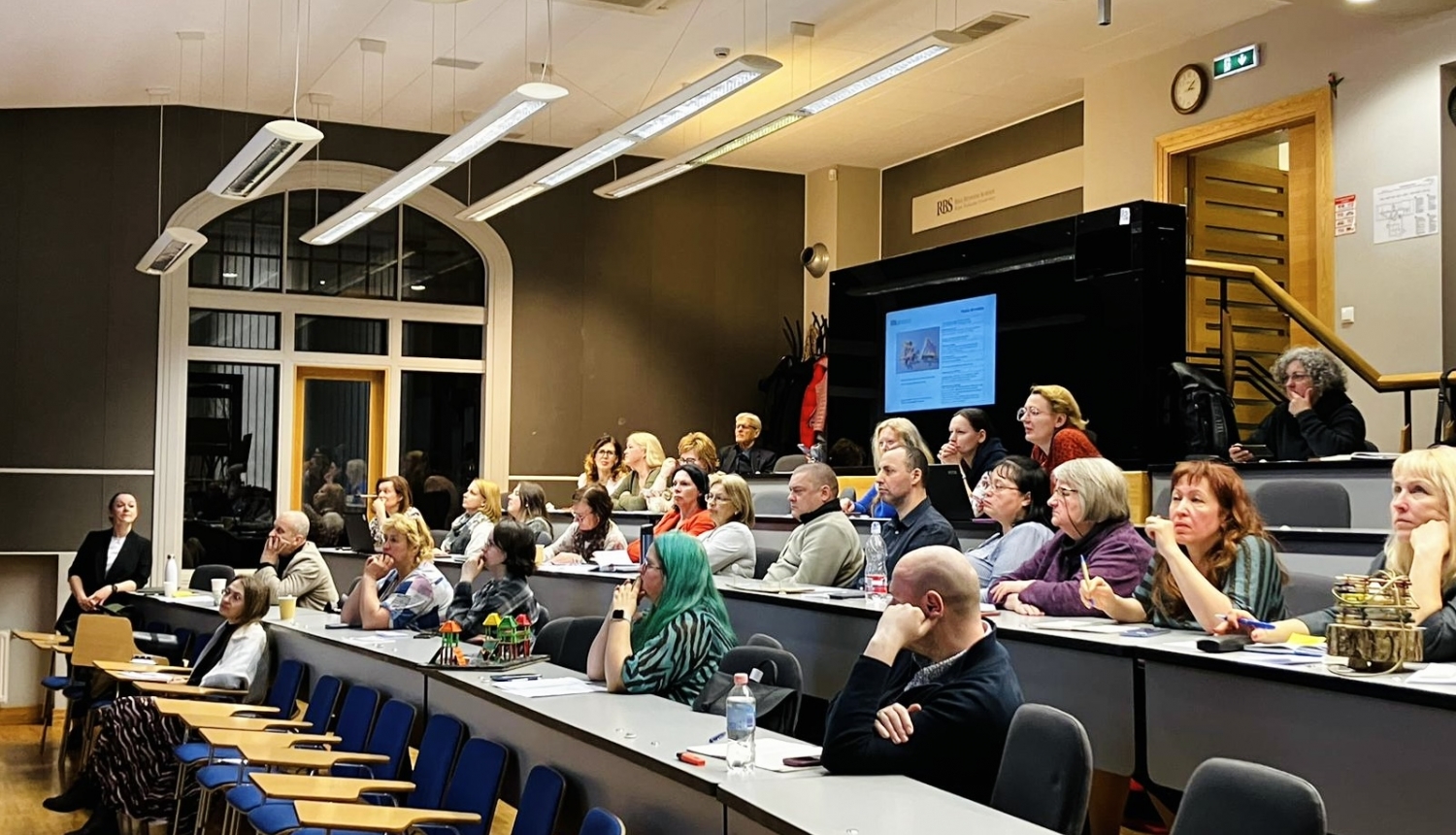 Cilvēki sēž auditorijā